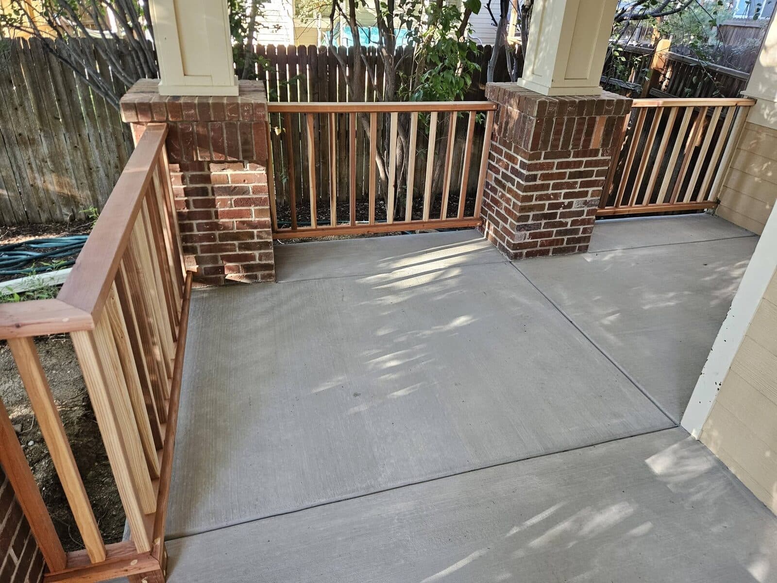 Concrete patio with brick and wood railings